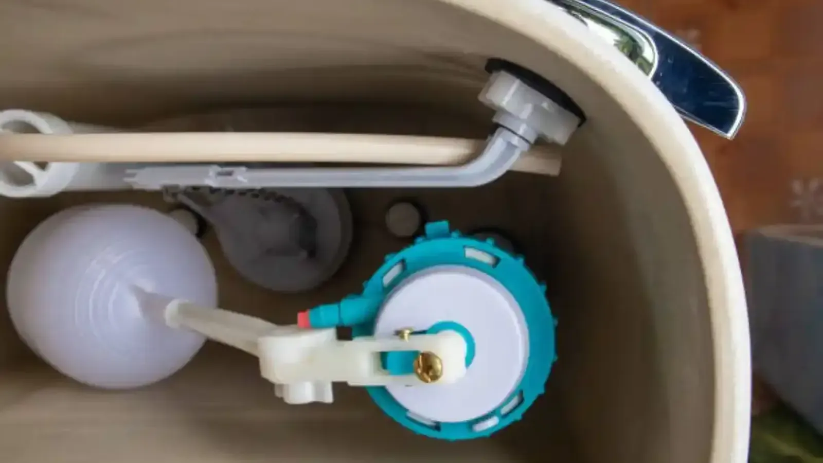Inside of a toilet tank showing the float, fill valve and flush mechanism
